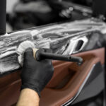 Wassen met schuim en detergent met een borstel op het binnenoppervlak van de autodoor. Auto detailing service